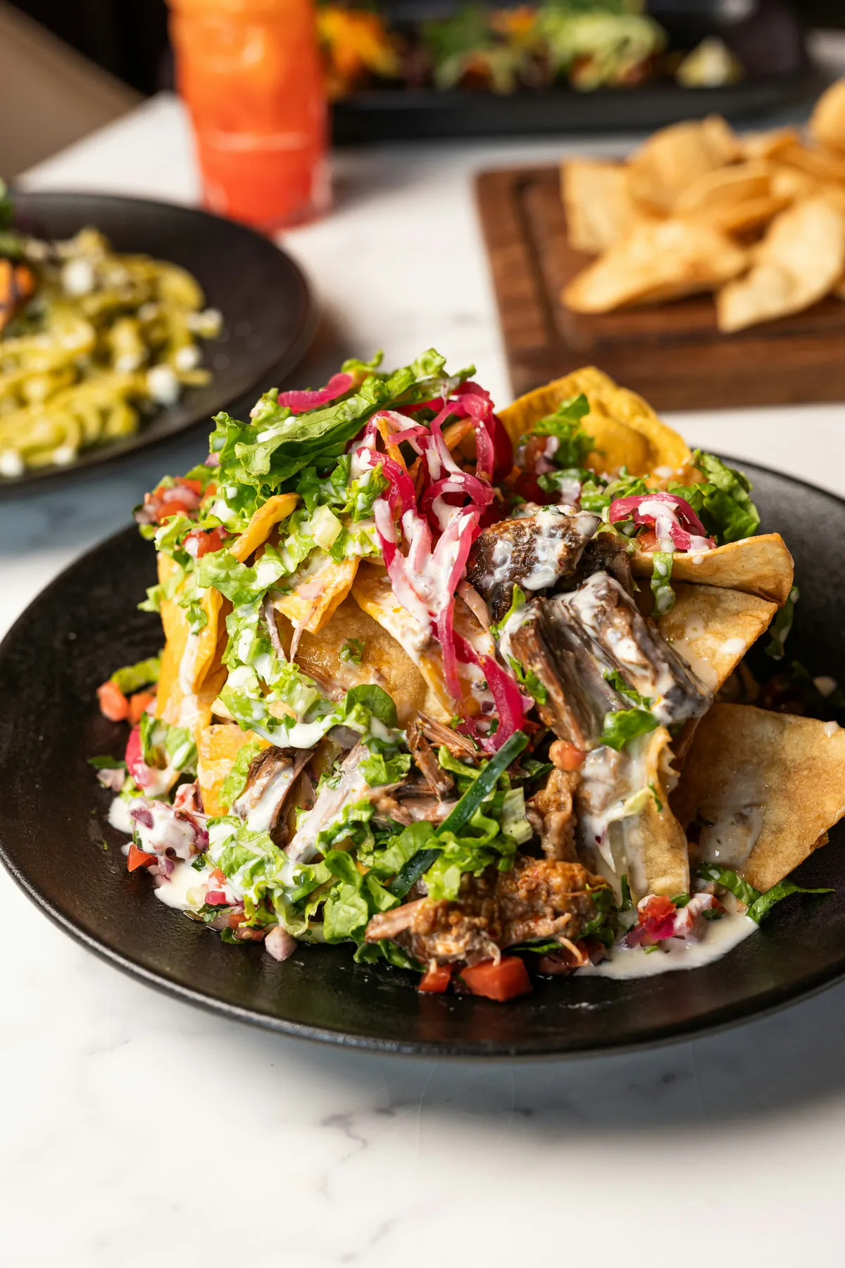 A colourful plate of grilled fish salad with pickled onions and plantain chips